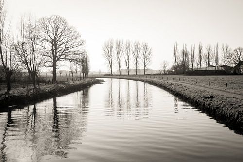Uitzicht over een smalle Nederlandse rivier in het winter seizoen