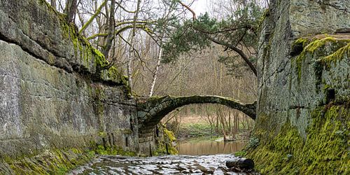 Old stone arch bridge between rocks 1