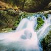 Wasserfall zwischen felsigem Fluss in den Bergen von Fotografiecor .nl