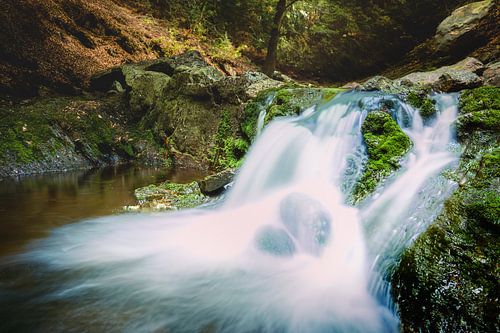 Waterfall among rocky river in the mountains