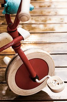 Kinderdreirad auf regennasser Terrasse