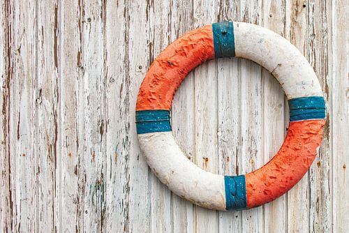 Alte Rettungsboje an einer Holzwand. von Ron van der Stappen