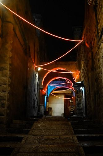 Straat verlicht met kerstverlichting en slingers, Nieuwjaar-Jeruzalem. Donkere nachtelijke smalle st