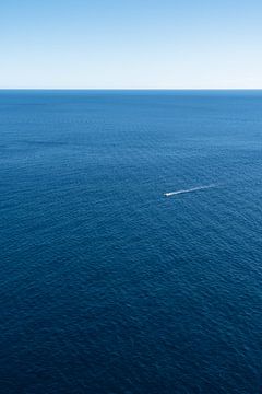 Un bateau et l'immensité bleue de la mer