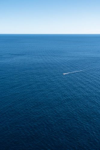 Een boot en de blauwe uitgestrektheid van de zee