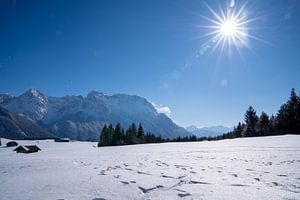 Verschneite Buckelwiesen bei Mittenwald, eingebettet in die winterliche Bergwelt der Alpen.
