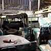 oude voertuigen staan te roesten in een boerenschuur van W J Kok