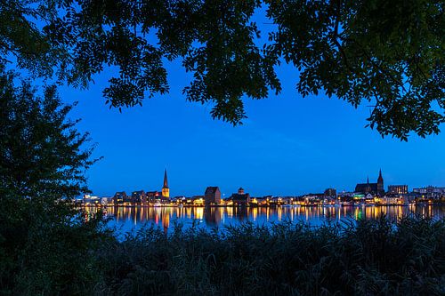 Blick über die Warnow auf die Hansestadt Rostock zur Blauen Stunde.