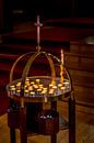 A round table with tea lights under a wooden crucifix in a monastry in Iceland par Hein Fleuren Aperçu
