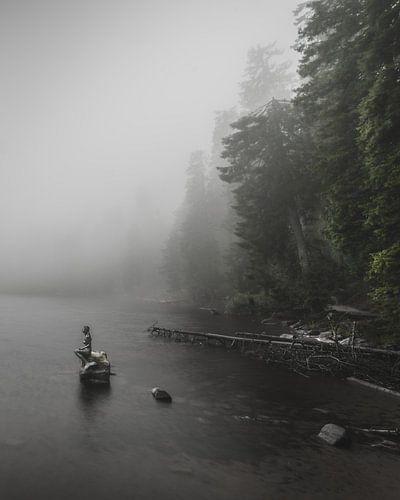 Landscape photo of a foggy misty lake with a statue of a mermaid