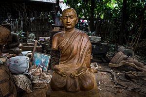Houten Budha beeld in achtertuin van dump