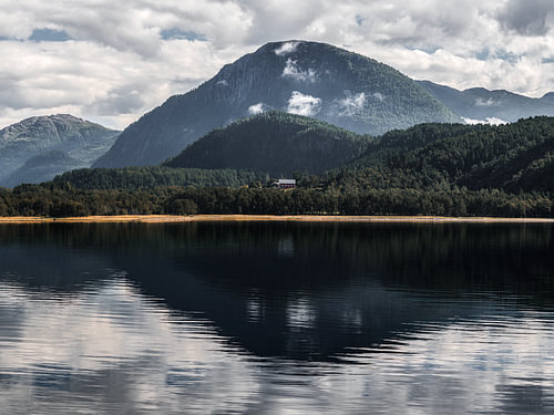 A picturesque reflection of Asbøsnyta and Skarfjellet in the Stangvikfjorden near Surnadal