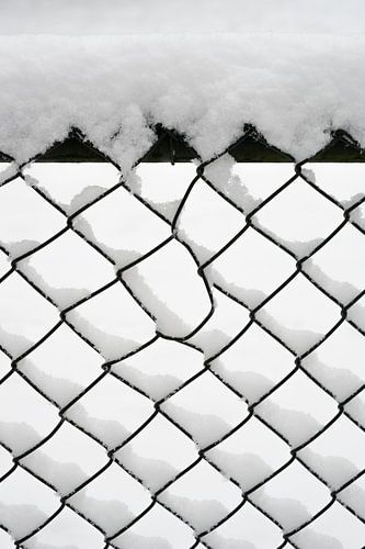 Minimalism in white: snow on a fence by Marjolijn van den Berg