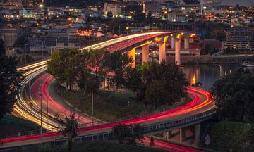 Des lumières qui coulent sur un pont dans une ville sur Rudolfo Dalamicio
