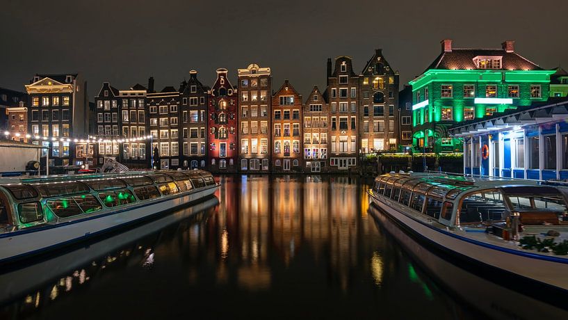 Medieval houses and canal boats on the Damrak in Amsterdam Netherlands by night by Eye on You