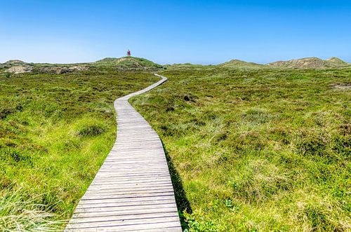 Passerelle en bois vers le phare dans les dunes sur Alexander Baumann