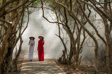 Two Vietnamese women walk among Mangrove trees by Anges van der Logt