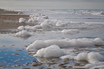Schuim op het strand van Zeeland op Foto