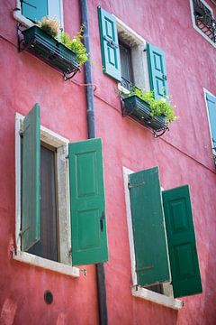 Rood geverfd Mediterraans huis met luiken