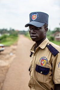 garde sur une route de terre en Ouganda