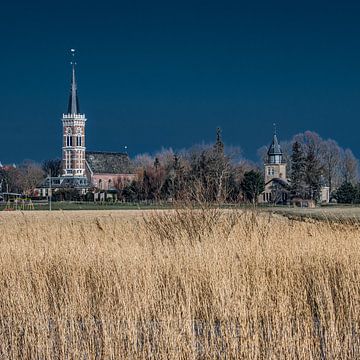 Het Friese dorpje Cornwerd met droog riet op de voorgrond. van Harrie Muis