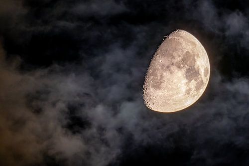 Waxing moon shines through the clouds