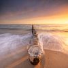 Golfbreker palen tijdens zonsondergang van Ellen van den Doel