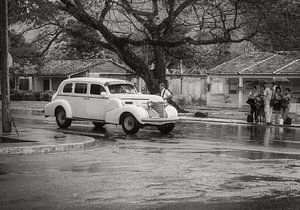 Liften in regenachtig Havana, witte oldtimer