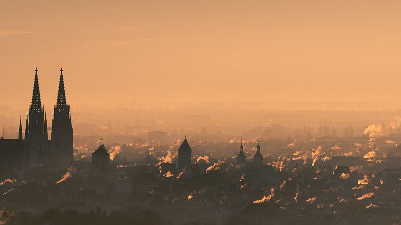 Overview of city skyline at the beginning of the heating period in autumn with many smoking chimneys by Robert Ruidl