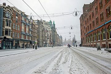 Damrak in de sneeuw in Amsterdam van Eye on You