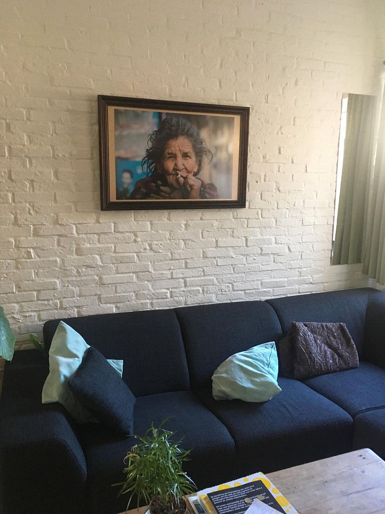 Old Nepalese woman smokes a cigarette by Ellis Peeters