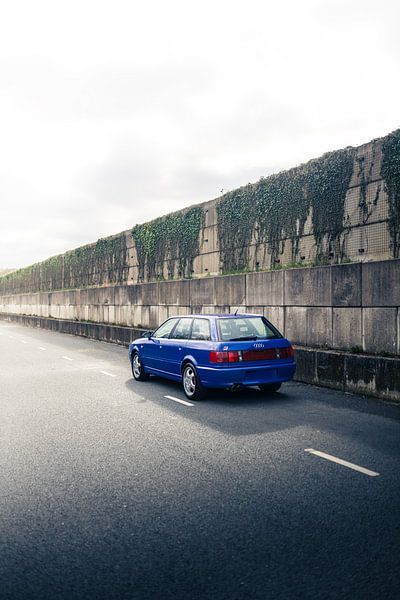 Blaue Audi RS2 auf langer Straße neben historischer Mauer von Sebastiaan van 't Hoog