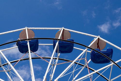 Reuzenrad met blauwe bakjes tegen blauwe lucht