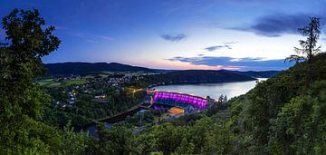 Panorama Edersee dam and village with purple illuminated dam wall at blue hour