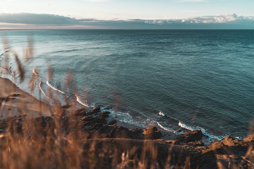 The sea with grass in the foreground in France by Martijn Joosse