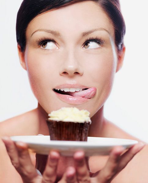 SF11289046 Woman licking her lips with a cupcake by BeeldigBeeld Food & Lifestyle