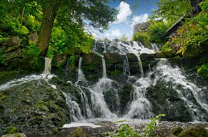 Kleiner Wasserfall im Wald mit Moos auf Steinen