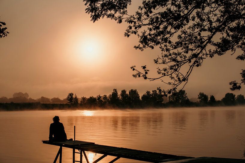 Une femme est assise sur un échafaudage au lever du soleil par ChrisWillemsen