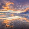 Avondrood boven de Waddenzee met een prachtige reflectie op het wad van de wolkenlucht van Bas Meelker