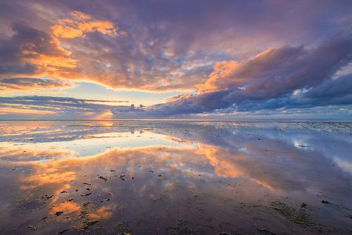 Evening red over the Wadden Sea with a beautiful reflection on the mud flats of the cloudy sky by Bas Meelker
