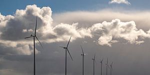 Windkraftanlagen mit blauem Himmel und weißen Wolken im Hintergrund