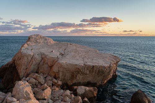 Lichtroze rotsen en de Middellandse Zee in de avond