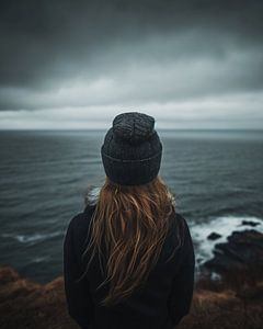Junge Frau schaut über die Küstenlandschaft