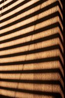 Motif d'un store vénitien au soleil sur une surface en bois