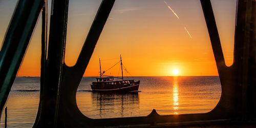 De ondergaande zon gezien door de vuurtoren van Hindeloopen