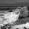 Des rochers dans le surf noir et blanc sur Jörg Hausmann
