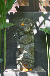 Balinesische Steinskulptur mit Blumen