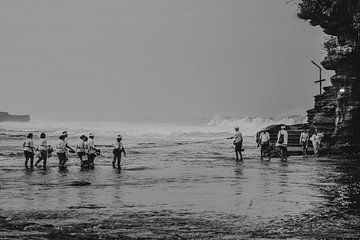 Balinezen die over het water lopen naar de Tanah Lot-tempel in het zwartwit van Marcus Photography