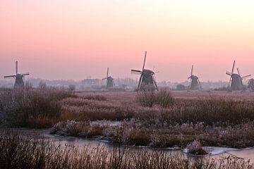 Traditionele molens bij Kinderdijk in de winter bij zonsondergang van Eye on You