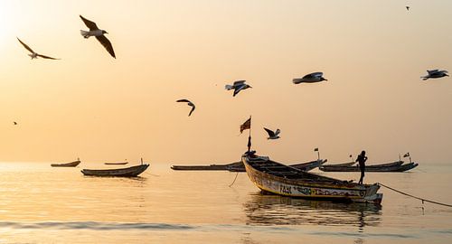 Zonsondergang in een vissersdorp in Gambia, Afrika.